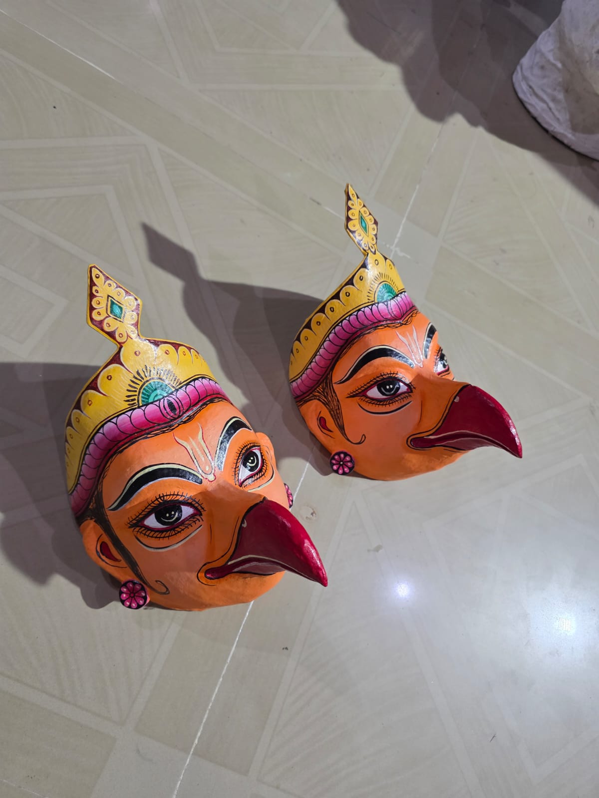 Two Jatayu masks drying in an artisan's workshop